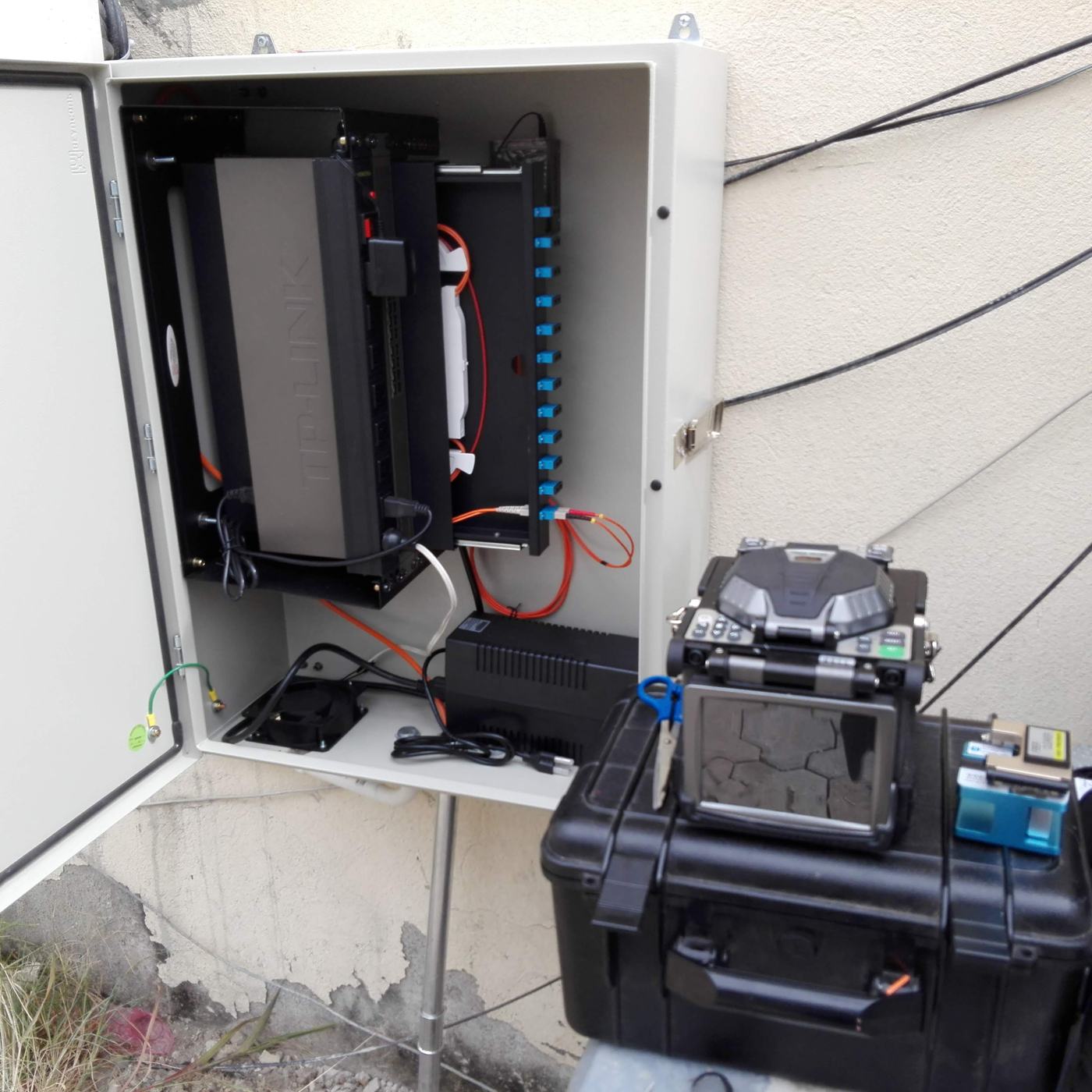 Fusionadora de fibra óptica trabajando junto a un gabinete